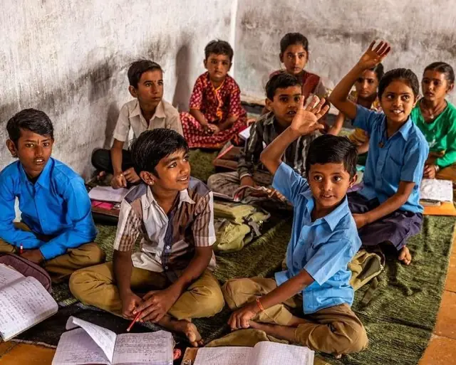 Children raising hands in a classroom